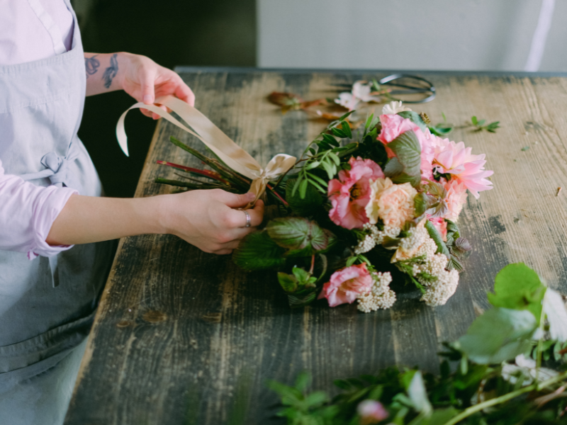 woman creating a floral bouquet